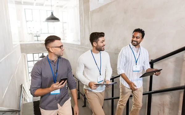 Mannen met conference badges die naar boven lopen — Stockfoto