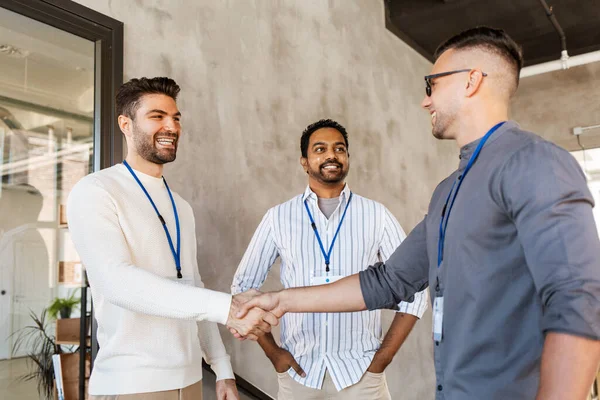 Glad affärsmän att göra handslag på kontor — Stockfoto