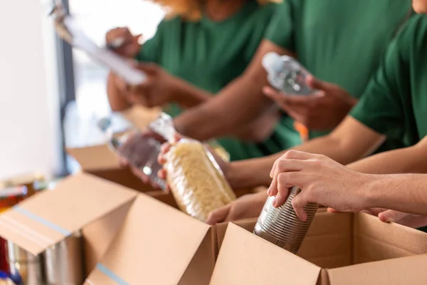 상자에 음식을 담아 포장하는 자원 봉사자들의 모습 — 스톡 사진