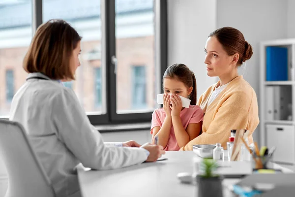 Mother, daughter blowing nose and doctor at clinic — Stock fotografie