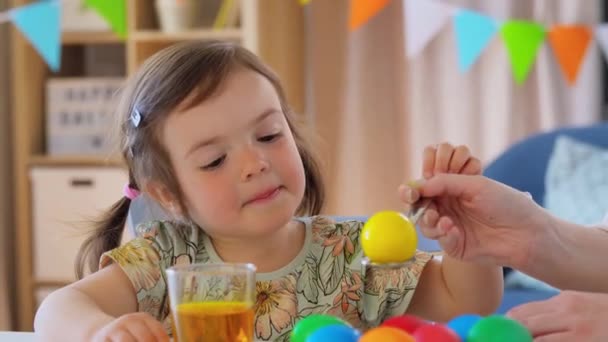 Mother with child dyeing easter eggs at home — Stock Video