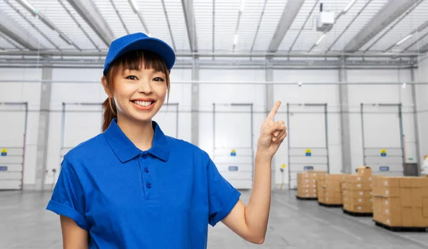 Happy smiling delivery woman over warehouse — Photo