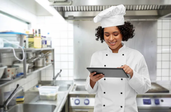 Улыбающаяся женщина-шеф-повар с планшетным компьютером — стоковое фото
