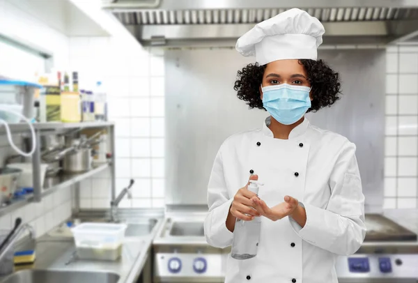 Női szakács maszkban kézfertőtlenítővel vagy szappannal — Stock Fotó