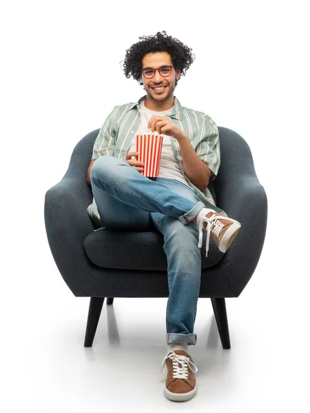 Sorridente giovane uomo con popcorn seduto sulla sedia — Foto Stock