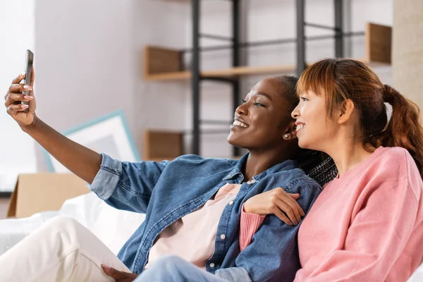 Mulheres com smartphone tirando selfie na nova casa — Fotografia de Stock