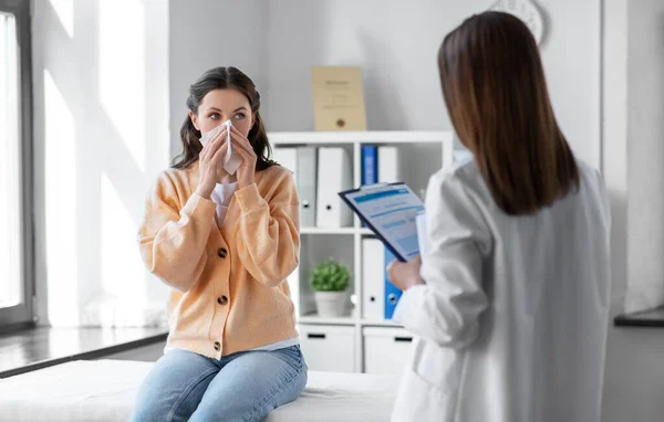 Female doctor and woman blowing nose at hospital — Zdjęcie stockowe