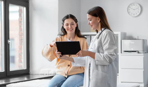 Female doctor with tablet pc and woman at hospital — Stock Fotó