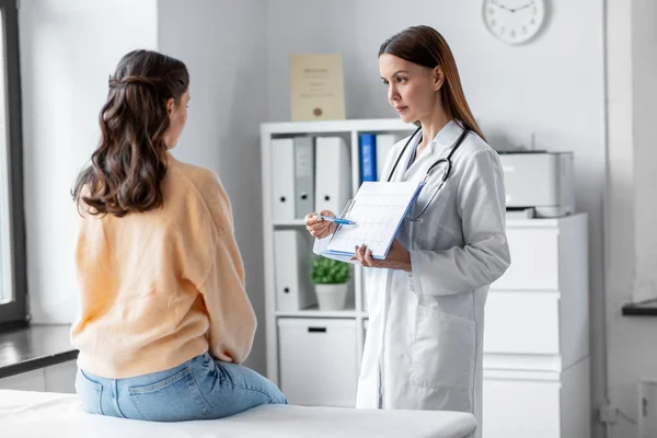 Doctor showing cardiogram to woman at hospital — Zdjęcie stockowe