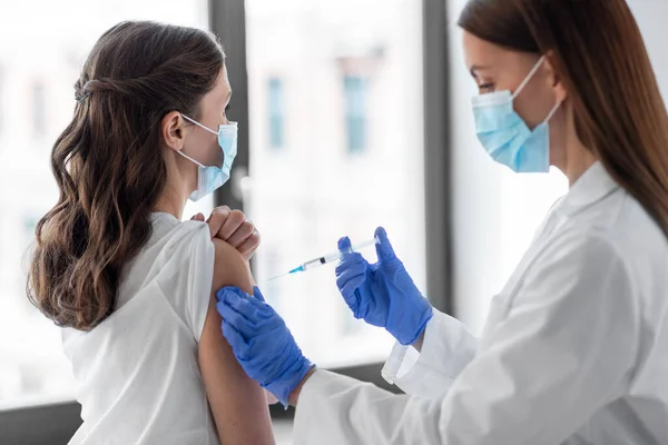 Female doctor with syringe vaccinating patient — Stock Photo, Image