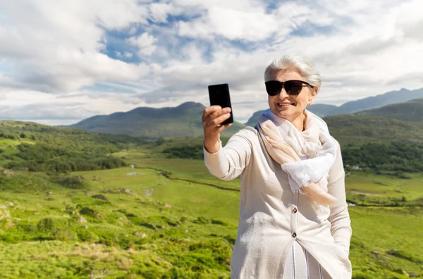 Seniorin macht Selfie mit Smartphone am Strand — Stockfoto