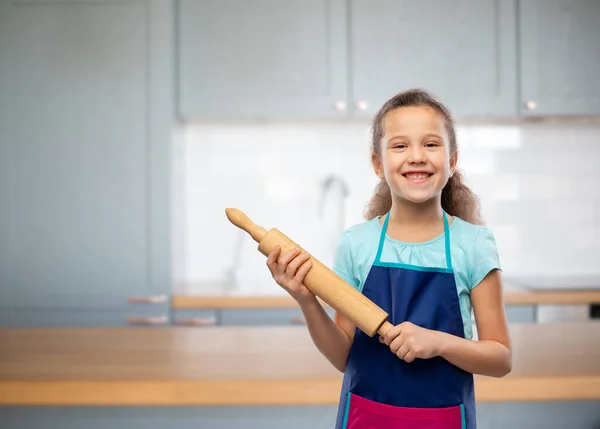 Sorridente bambina in grembiule con mattarello — Foto Stock