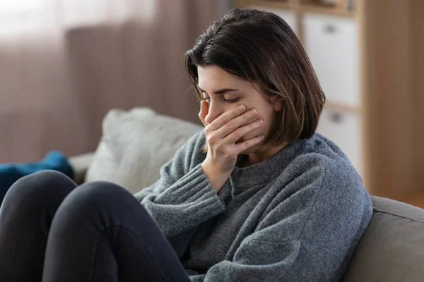 Stresszes nő ül a kanapén otthon — Stock Fotó