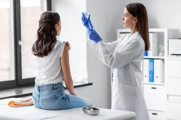 Female doctor with syringe vaccinating patient — Stock Photo, Image