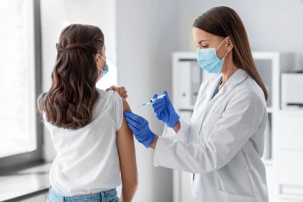 Female doctor with syringe vaccinating patient — Stock Photo, Image