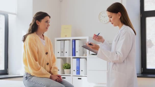 Female doctor and woman with sore arm at hospital — Stockvideo