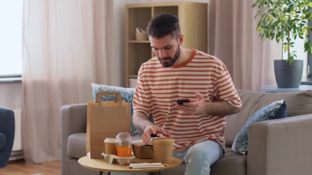 Man with phone checking food order at home — Stockvideo