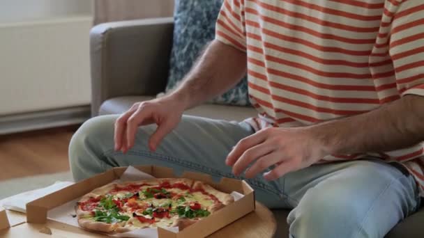 Adam kutuyu açıyor ve pizza yiyor. — Stok video
