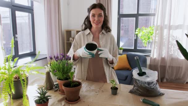 Счастливая женщина или блоггер посадки цветов дома — стоковое видео