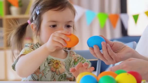 Baby girl and mother beating easter eggs at home — Wideo stockowe