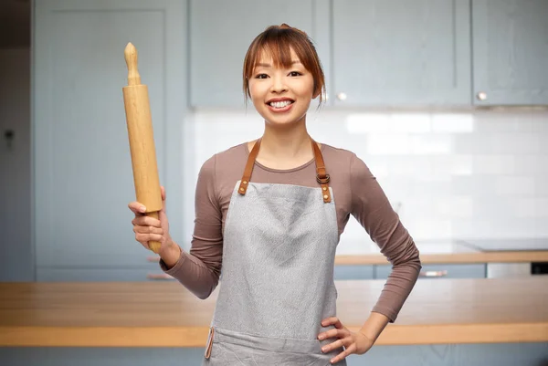 Femme heureuse dans tablier avec rouleau à pâtisserie dans la cuisine — Photo