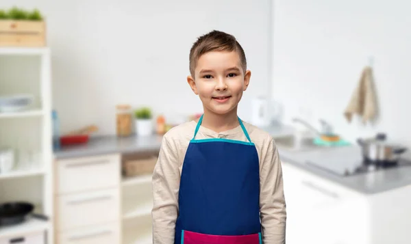 Mosolygós kisfiú kötényben a konyhában — Stock Fotó