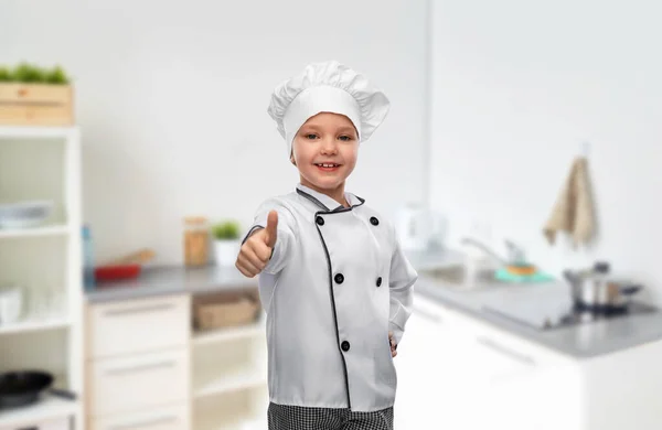 Mädchen in Haube zeigt Daumen nach oben in Küche — Stockfoto