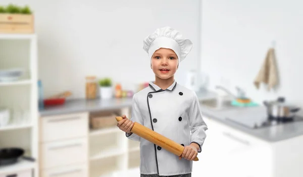 Menina em chefs toque com rolo de pino na cozinha — Fotografia de Stock
