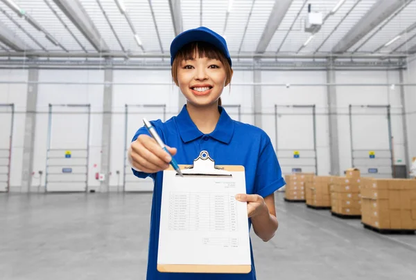 Happy delivery woman with clipboard and pen — Stock Photo, Image