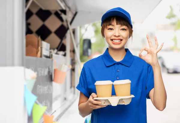 Delivery woman with coffee cups showing ok sign — Stock Photo, Image