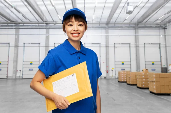 Delivery woman with parcel envelope at warehouse — Stock Photo, Image