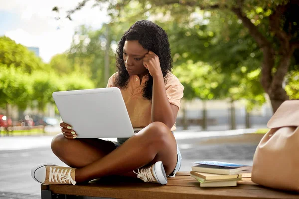 Afrikanska student flicka med bärbar dator och böcker i staden — Stockfoto