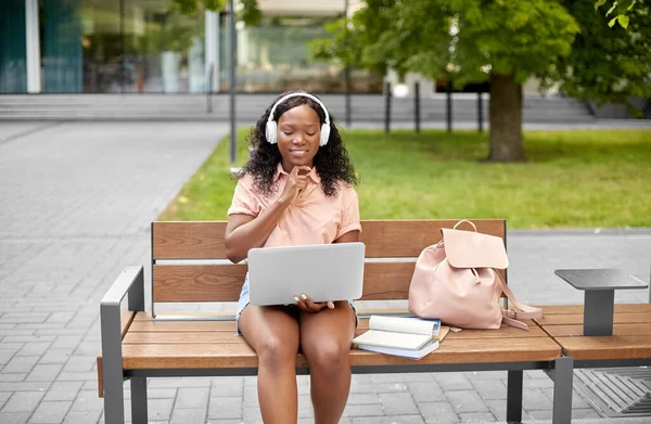 African student girl in headphones with laptop — Stock Photo, Image