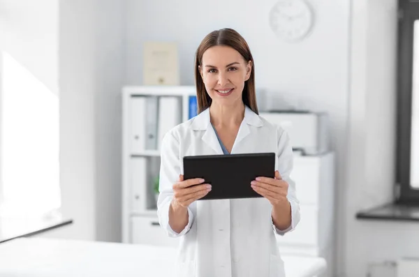 Medico sorridente femminile con tablet pc in ospedale — Foto Stock