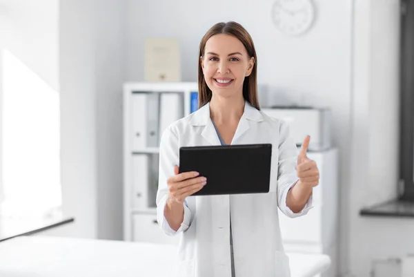 Smiling female doctor with tablet pc at hospital — Stok fotoğraf