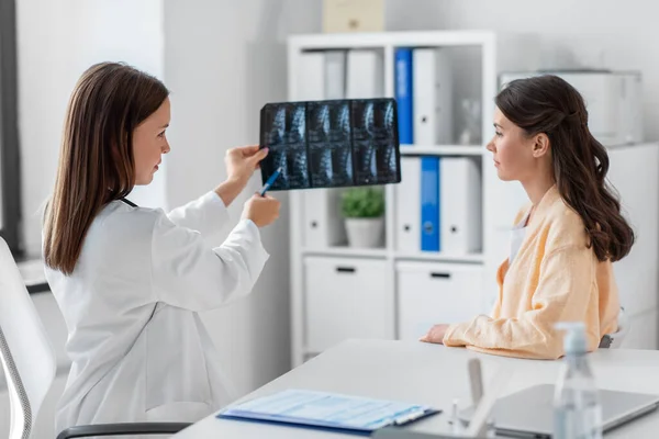 Lekarz pokazujący zdjęcie rentgenowskie kobiecie w szpitalu — Zdjęcie stockowe