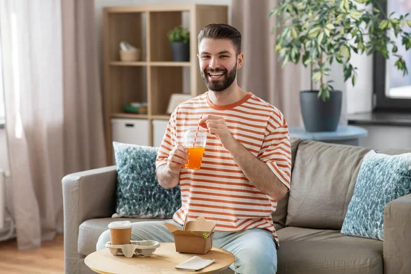 Smiling man with takeaway food and drinks at home — Foto de Stock