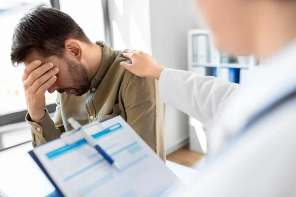 Doktor ve hastanede sağlık sorunu olan üzgün bir adam. — Stok fotoğraf