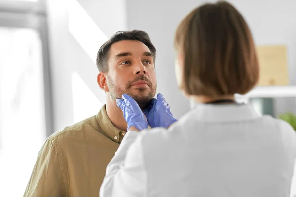 Läkare kontrollera lymfkörtlar av man på sjukhus — Stockfoto