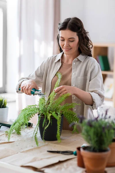 Woman cutting flowers leaves with pruner at home — Photo