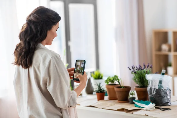 Woman with smartphone photographing pot flowers — Stock Photo, Image