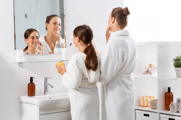 Moeder en dochter met moisturizer in de badkamer — Stockfoto