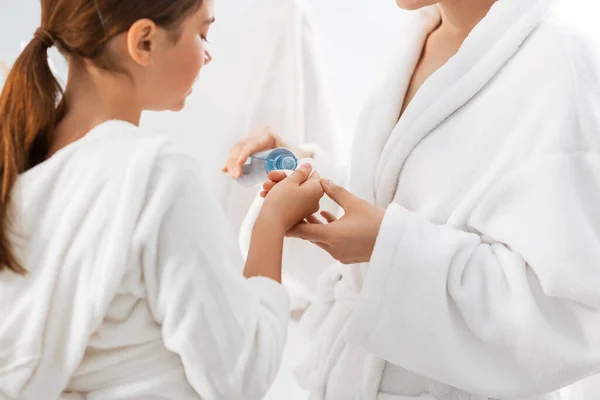 Mor och dotter applicera lotion på bomullspad — Stockfoto