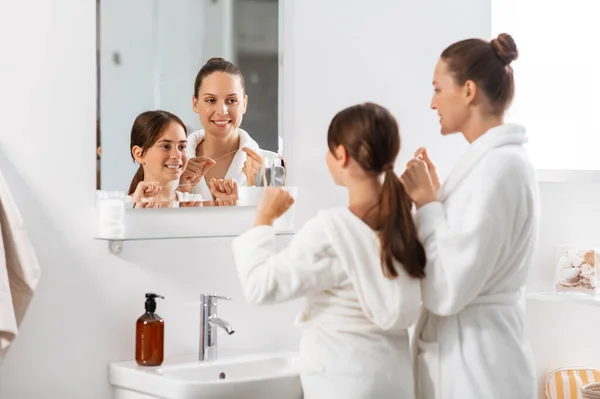 Mother and daughter with floss cleaning teeth — Stock Photo, Image