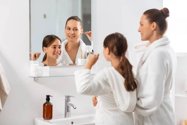 Mother and daughter looking to mirror at bathroom — Stock Photo, Image