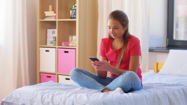 Genç kız evde akıllı telefondan mesaj atıyor. — Stok video