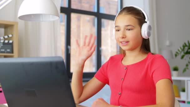 Дівчина в навушниках з ноутбуком вдома — стокове відео