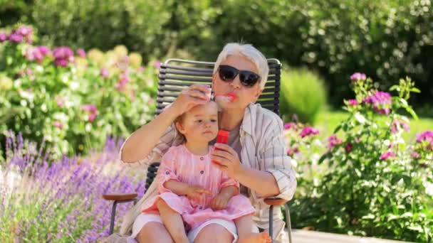 Glückliche Oma und kleine Enkelin im Garten — Stockvideo