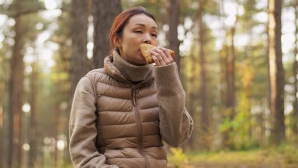 Nő iszik tea és eszik szendvicset az erdőben — Stock videók