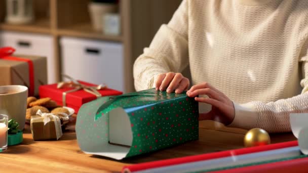 Mujer envolviendo el regalo de Navidad en papel en casa — Vídeo de stock